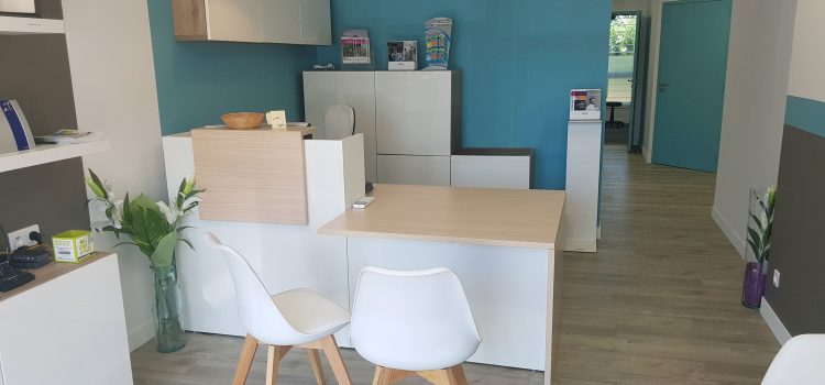 Vue intérieure moderne du centre auditif Audilab avec sièges confortables, bureau d'accueil et décoration épurée.