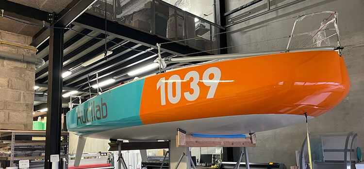 Ce voilier de série mesurant 6.50 m de long dont le mat culmine à 12 m de hauteur pèse 970 kg. Sa vitesse de pointe peut atteindre 37 km/h. Il est spécialement conçu pour les courses de haute mer et porte les couleurs d’Audilab.